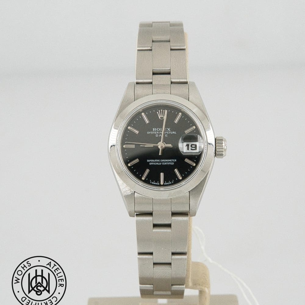 Rolex Oyster Perpetual Date wristwatch with black dial, date window, and stainless steel bracelet on display.