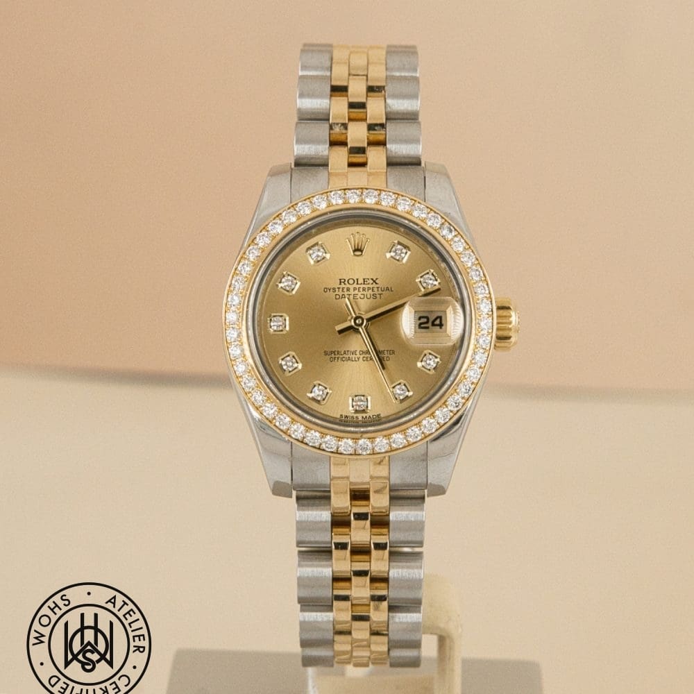 Two-tone Rolex Datejust wristwatch with diamond bezel and diamond hour markers on a gold dial