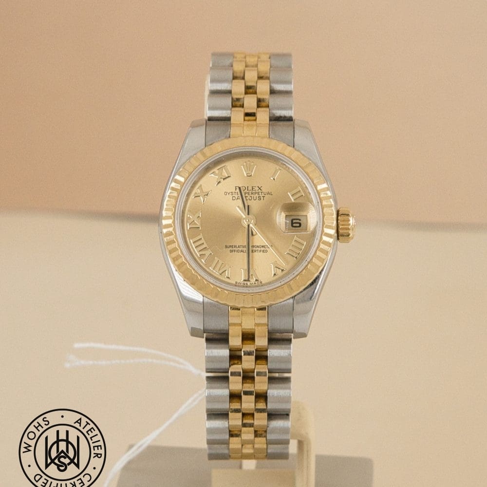 Two-tone Rolex Datejust wristwatch on display with a gold fluted bezel, Roman numeral markers, and a date window at 3 o'clock.