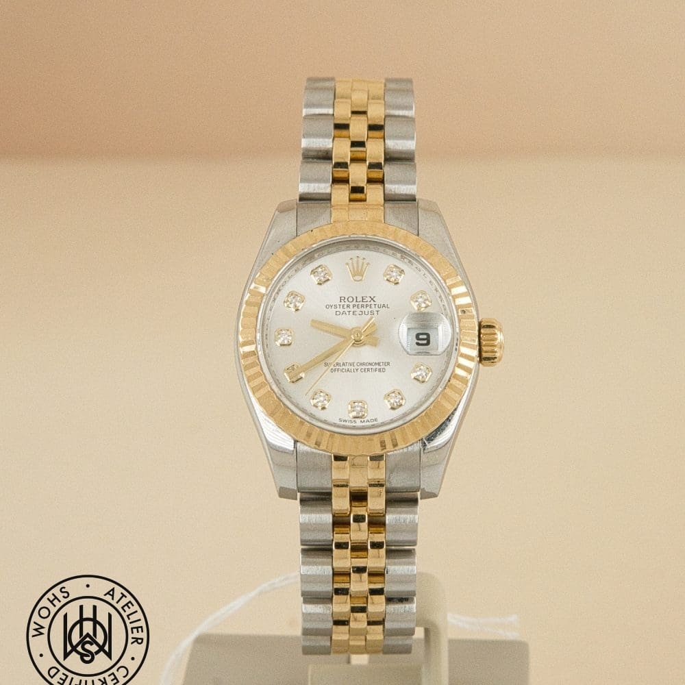 Two-tone Rolex Datejust wristwatch with diamond hour markers on a beige background