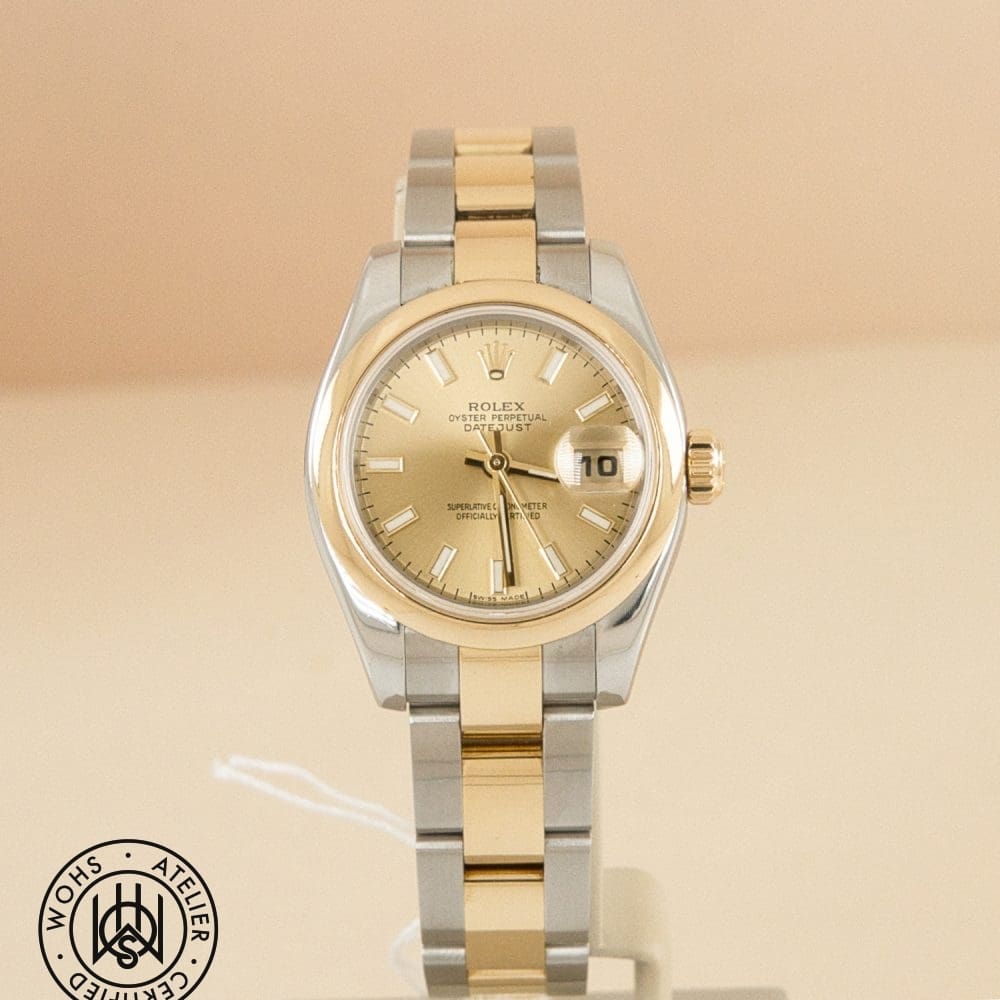 Two-tone Rolex Datejust wristwatch on a display, gold and silver bracelet with a champagne dial and a date window set to 10.