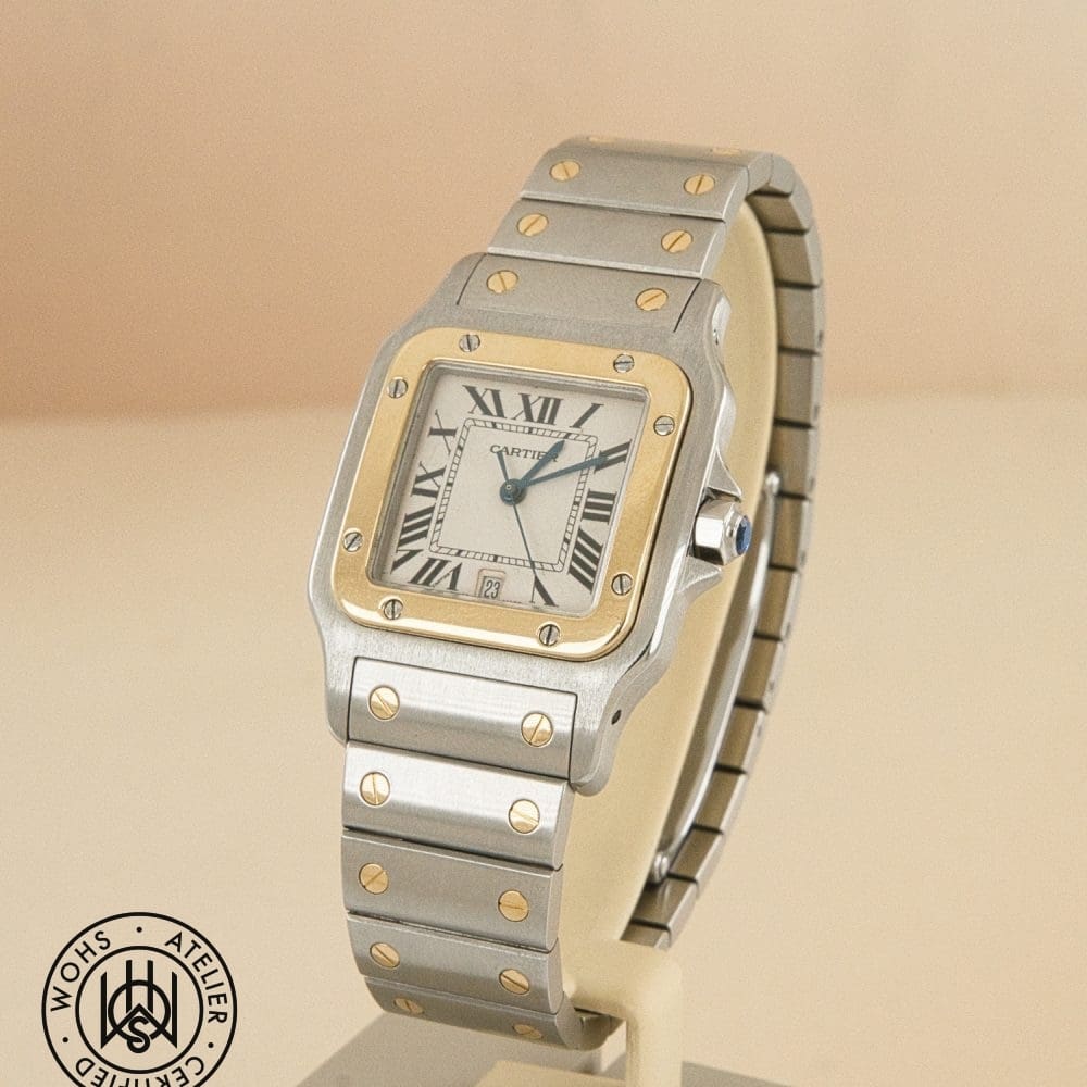 Cartier wristwatch with a two-tone metal case and gold bezel, Roman numeral dial on a beige background, date window visible. DSC03080