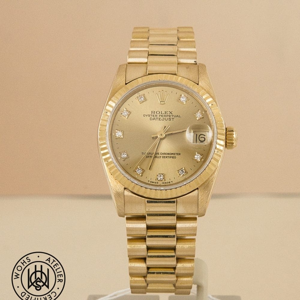 Gold Rolex Datejust wristwatch with diamond hour markers and a fluted bezel photographed on a display stand. DSC03163
