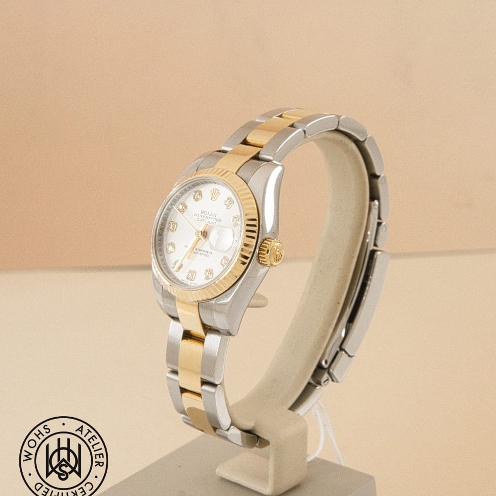 Two-tone gold and stainless Rolex Datejust watch on a display stand with a certification seal in the corner. DSC03251