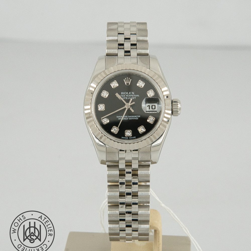 Rolex Datejust stainless steel watch with diamond hour markers and date window showing 10, on a display stand