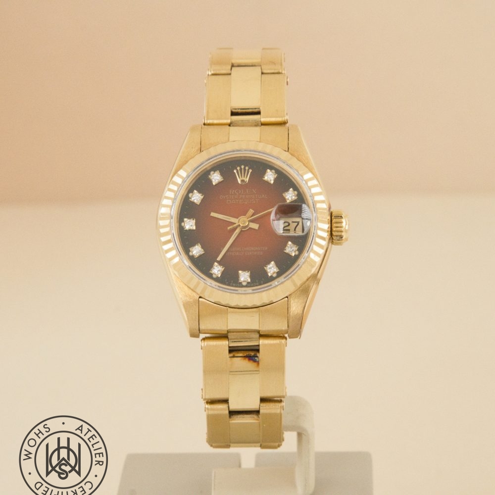 Gold Rolex Datejust watch with diamond hour markers on display, date window showing 27.