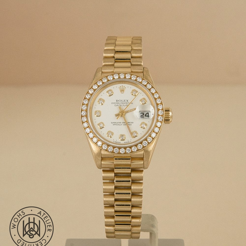 Gold Rolex Datejust watch with diamond-studded bezel and white dial showing date at 3 o'clock on a gold bracelet. DSC03308