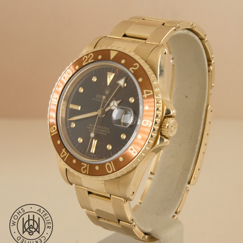 Gold Rolex GMT-Master wristwatch with a brown 24-hour bezel and black dial, magnified date window visible. DSC03317