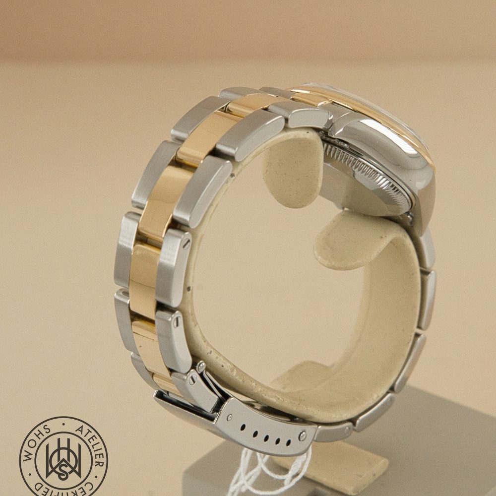 Close-up of a two-tone gold-and-silver metal wristwatch on a display stand, with a circular certification seal visible in the bottom left. Preowned Rolex Lady Datejust 79163 silver diamond 5