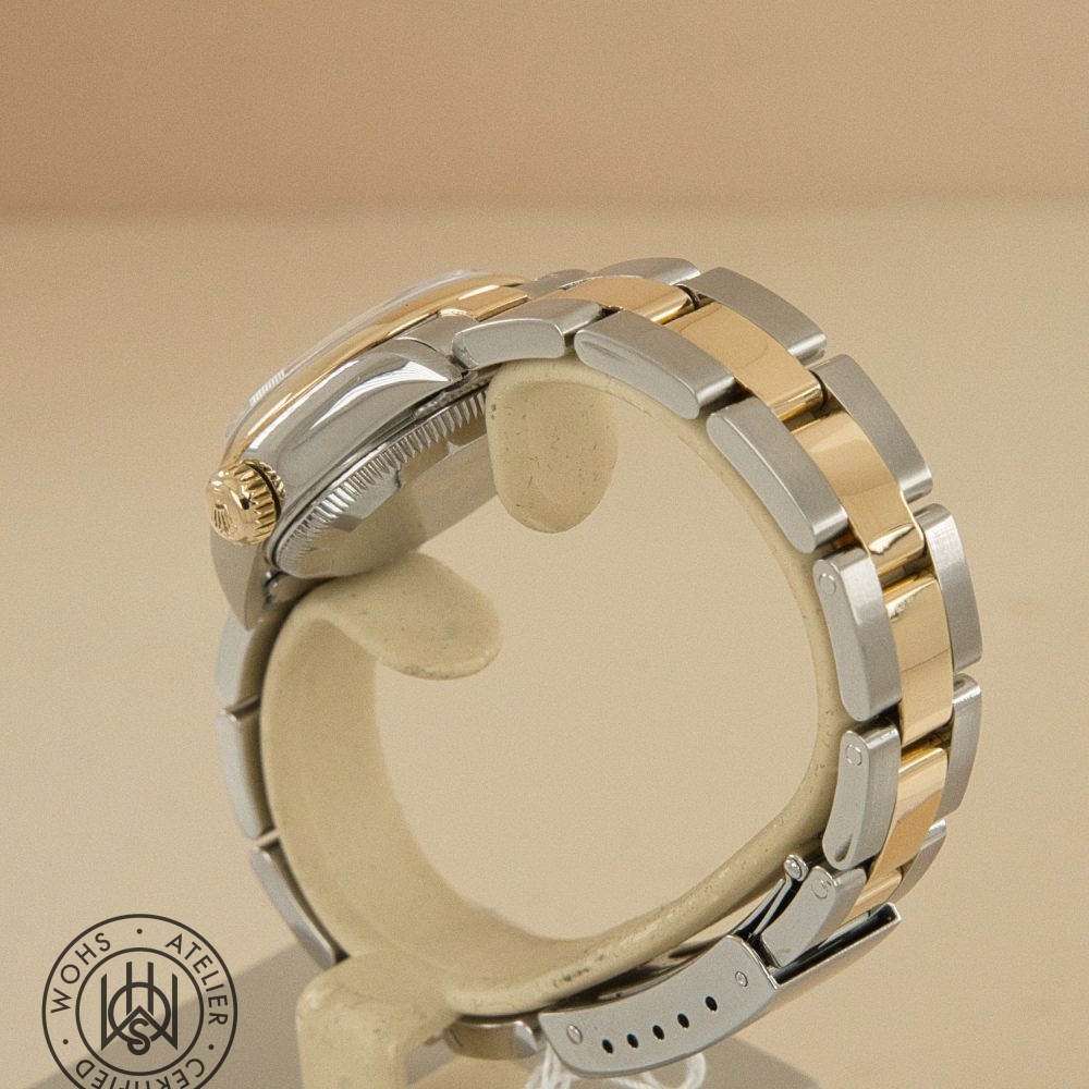 Close-up of a two-tone (silver and gold) metal wristwatch band and case, crown visible on the side, photographed from the side. Watermark seal appears in the bottom-left. Preowned Rolex Lady Datejust 79163 silver diamond 6
