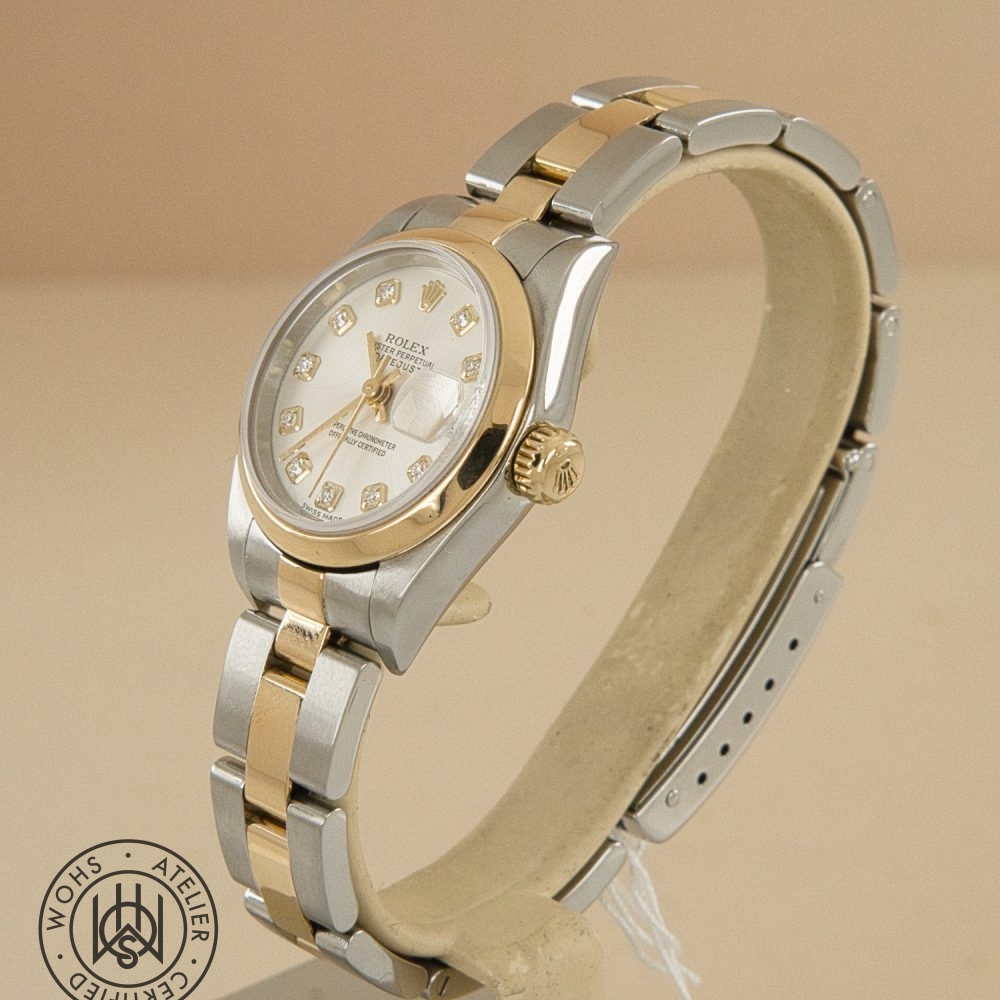 Two-tone Rolex Datejust wristwatch with gold and steel bracelet and diamond hour markers on a light beige background. Preowned Rolex Lady Datejust 79163 silver diamond 7