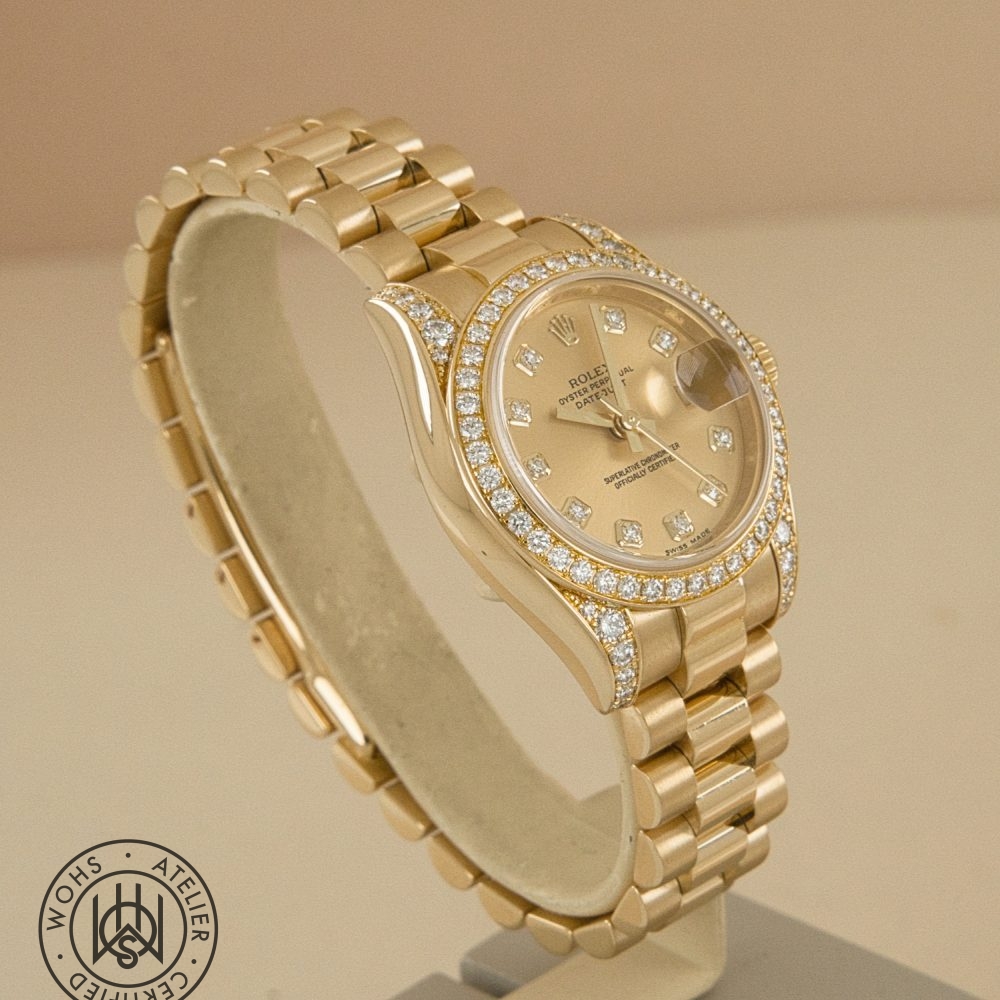 Gold Rolex Datejust watch with diamond bezel and diamond hour markers, displayed on a stand. Preowned Rolex Lady Datejust reference 179158 factory set lugs and bezel 4