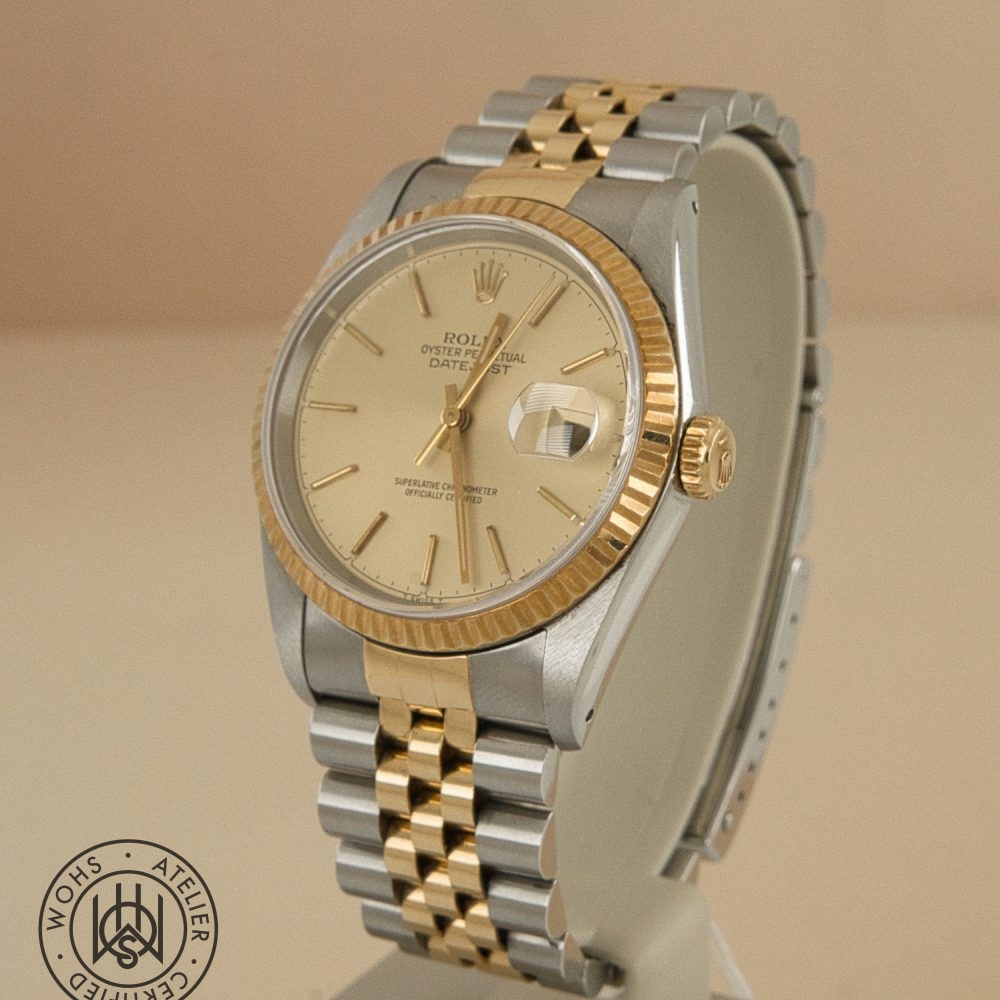 Two-tone Rolex Datejust wristwatch with a gold fluted bezel, champagne dial, and Jubilee bracelet on display. Rolex Datejust 36mm reference 16233 1