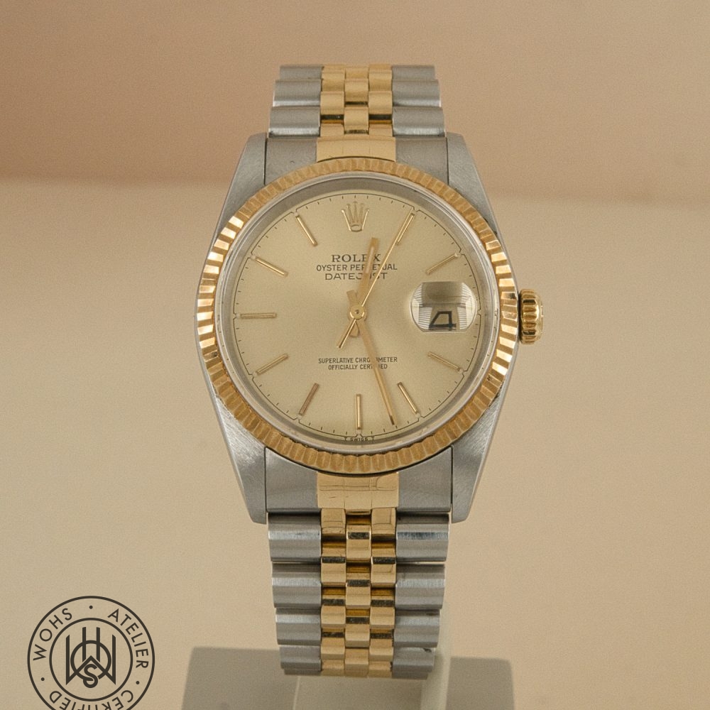 Two-tone Rolex Datejust wristwatch with gold bezel and bracelet on a display stand. Rolex Datejust 36mm reference 16233 2
