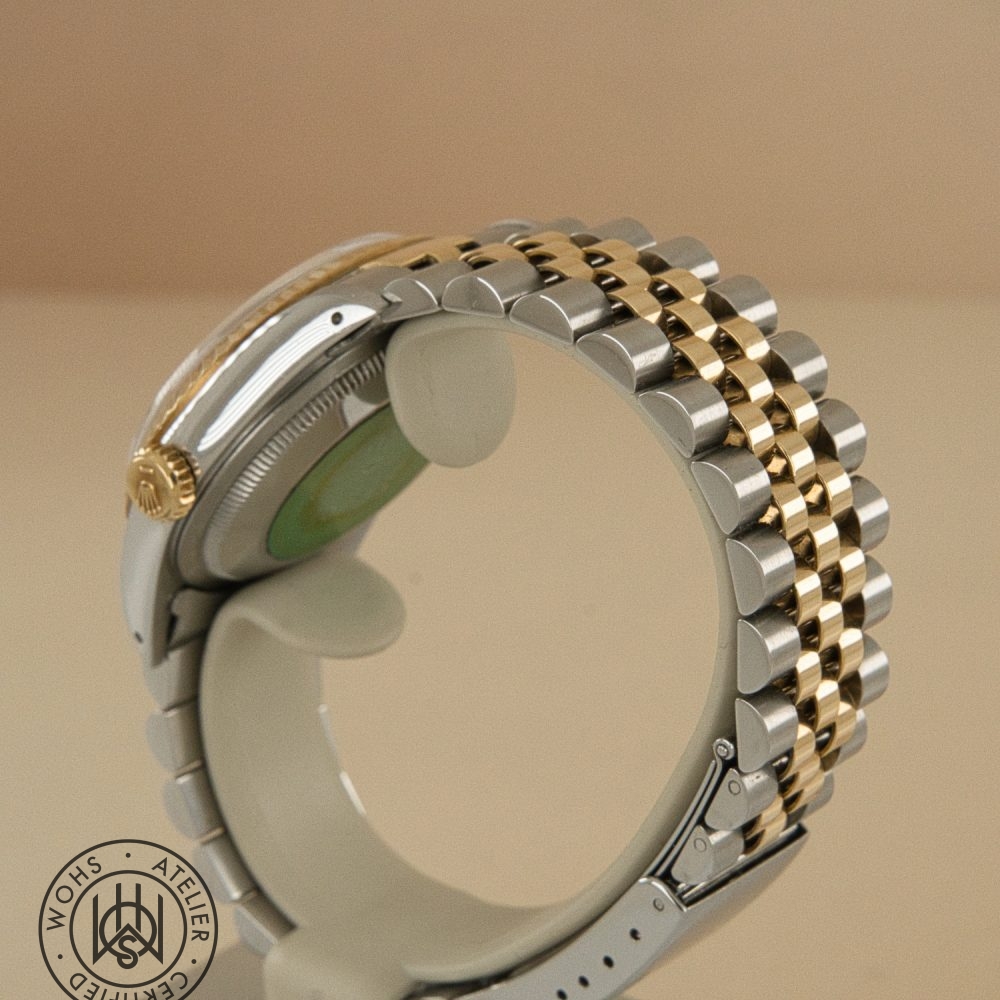 Two-tone metal wristwatch with gold and silver links seen from the side; crown on the left, watermark stamp bottom-left. Rolex Datejust 36mm reference 16233 5