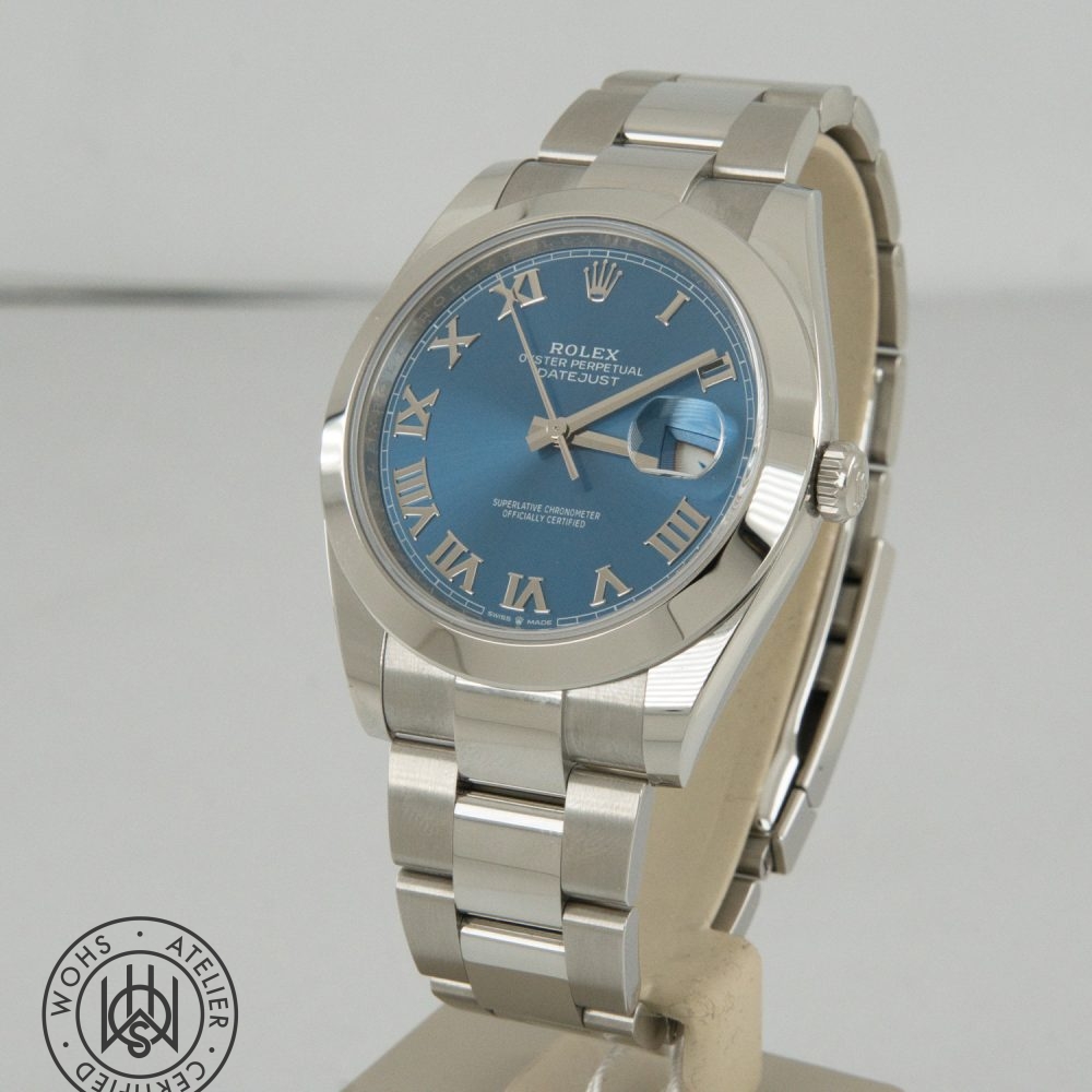 Rolex Oyster Perpetual Datejust: stainless steel watch with a blue dial, Roman numeral hour markers, and a date window with cyclops magnifier on a display stand Rolex Datejust 41 2026 reference 126300 box papers blue azzuro dial 1
