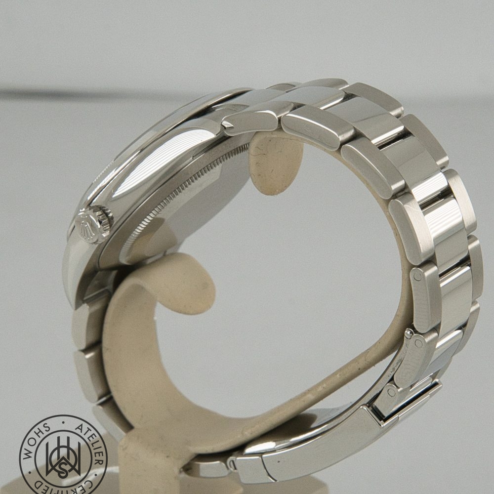 Side view of a silver stainless steel wristwatch on a display stand, showing the case, crown, and linked bracelet. Rolex Datejust 41 2026 reference 126300 box papers blue azzuro dial 5
