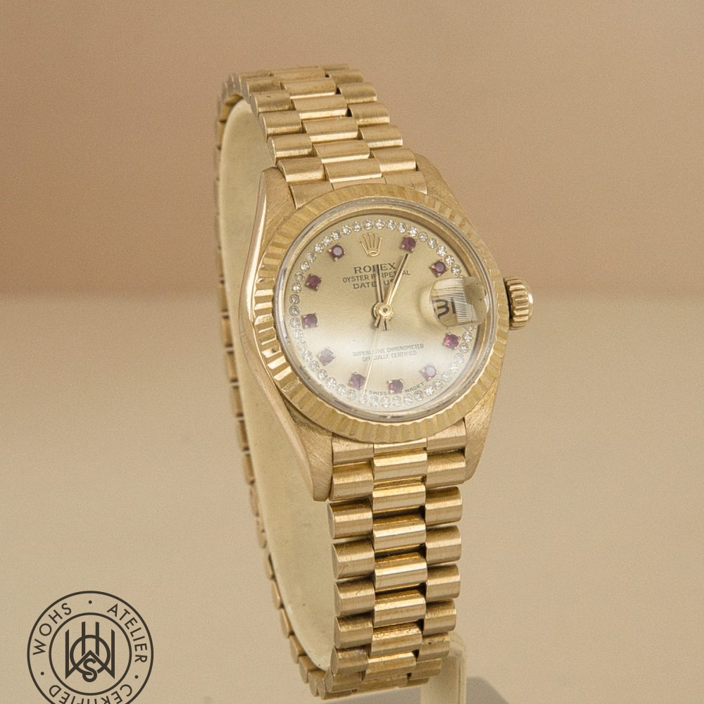 Gold Rolex Oyster Perpetual Datejust wristwatch with diamond hour markers and a jeweled bezel, showing the date through a magnifier. Rolex Ladies Datejust reference 69178 - Diamond and Ruby Dial Pave 18ct Gold Dial 3