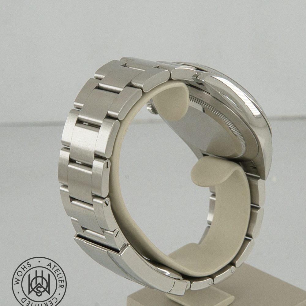 Close-up of a stainless steel watch bracelet on a display stand, viewed from the side; a circular watermark is in the bottom-left corner. Rolex Oyster Perpetual Pre-Owned reference 134300 41mm silver dial box papers 2025 5