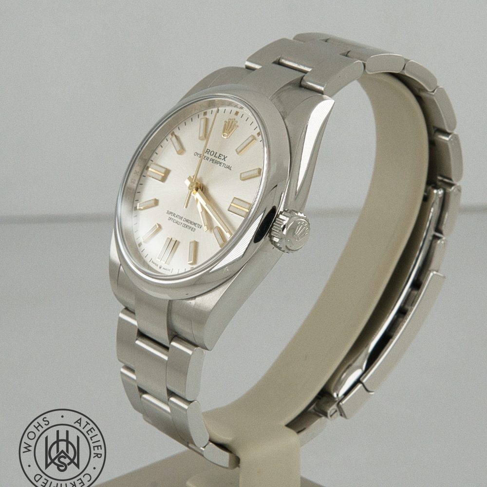 Stainless steel Rolex Oyster Perpetual wristwatch on a display stand with a silver dial and gold-tone markers and hands. Rolex Oyster Perpetual Pre-Owned reference 134300 41mm silver dial box papers 2025 7