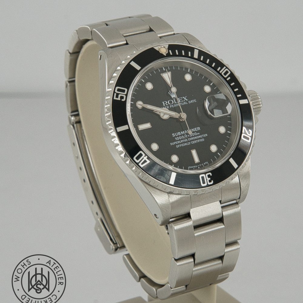 Close-up of a stainless steel Rolex Submariner watch with a black bezel and date window, angled on a display stand. Rolex Submariner reference 16610 preowned 1998 box papers 3